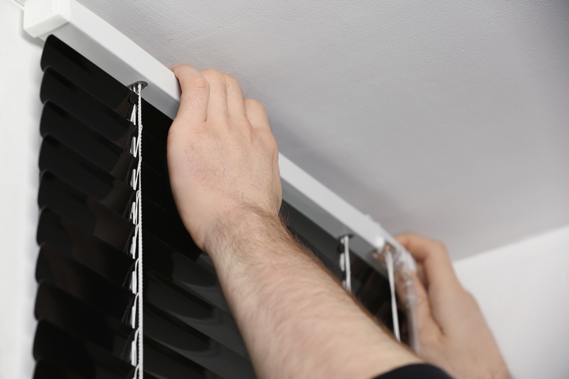 Worker Installing Window Blinds